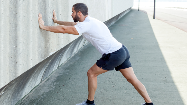 man using kaizo health calf stretch to prepare for race in rockville, md